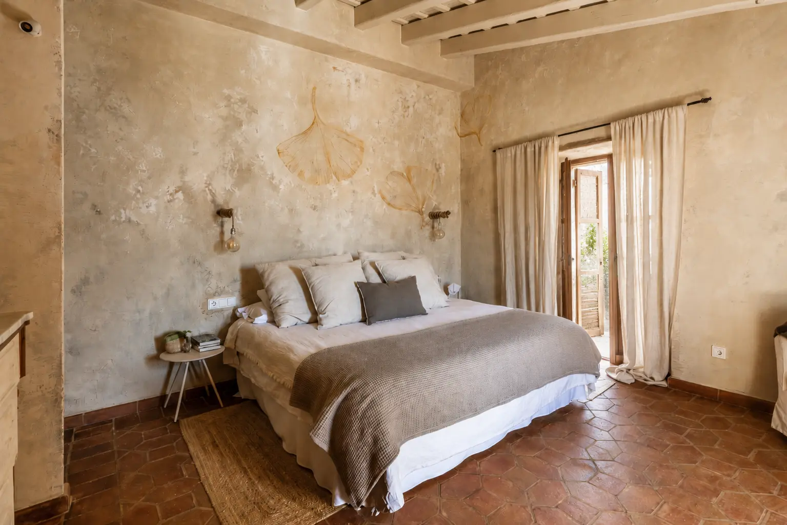 Dormitori wabi-sabi de Núria Gich amb parets de textura natural i llit de matrimoni